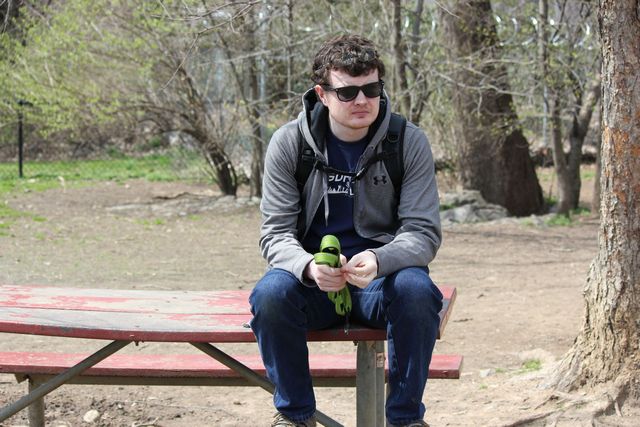 Me sitting on a picnic table holding a leash